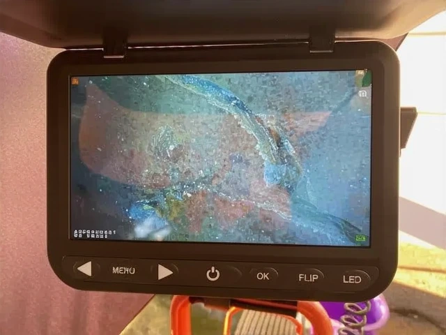 Customer photo of drain cleanout showing backed up water and sediment buildup